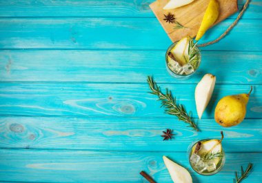 Armut kokteyl ROM, likör, armut dilimleri ve biberiye mavi ahşap masa, seçici odak