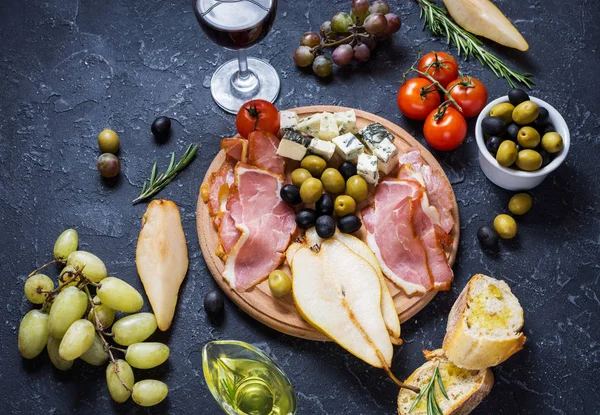 Meze, İtalyan meze, jambon, zeytin, peynir, ekmek, üzüm, armut ve şarap taş zemin üzerine