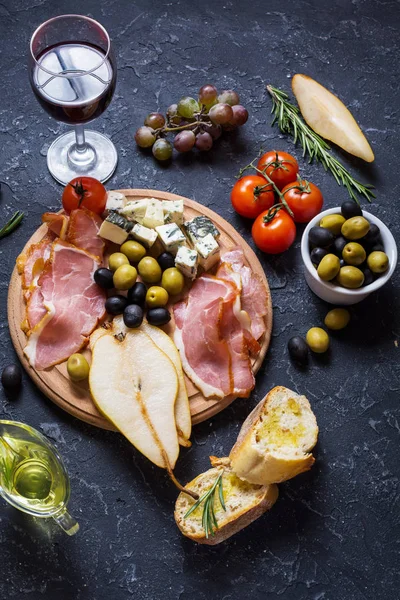 Meze, İtalyan meze, jambon, zeytin, peynir, ekmek, üzüm, armut ve şarap taş zemin üzerine