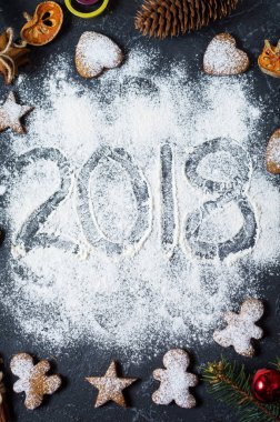 Mutlu yeni yıl 2018 un ve Noel süslemeleri Gingerbread çerezleri karanlık taş zemin üzerine yazılmış. Noel kartı, yılbaşı tebrik kartı.