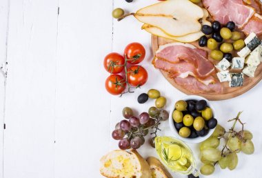 Meze, İtalyan meze, jambon, zeytin, peynir, ekmek, üzüm, armut Beyaz ahşap zemin üzerinde