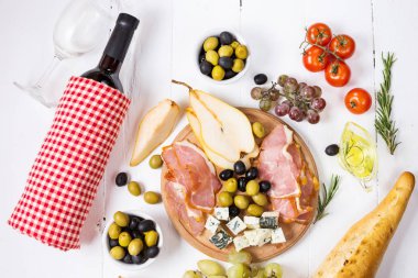 Meze, İtalyan meze, jambon, zeytin, peynir, ekmek, üzüm, armut ve şarap Beyaz ahşap zemin üzerinde