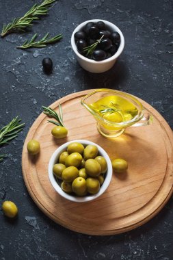 Ahşap kase taş siyah arka plan üzerine siyah ve yeşil zeytin