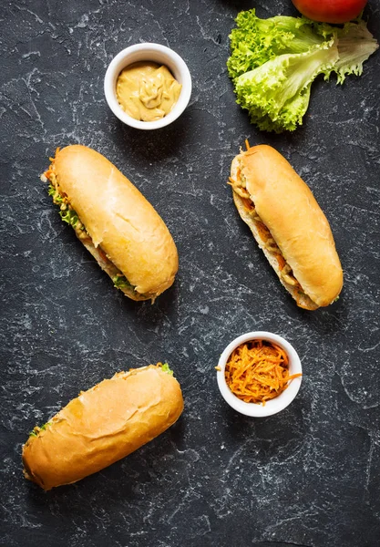 Hot dog con sottaceti e lattuga su sfondo di cemento — Foto Stock