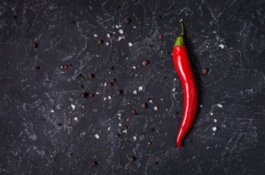 Kırmızı sıcak biber pepeprs ve siyah taş zemin, üstten görünüm üzerine karabiber