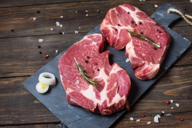 Çiğ et biftek çeşnilikler ahşap arka plan ile. Biftek yemek için hazır. Barbekü kavramı. Et kavurma için malzemeler