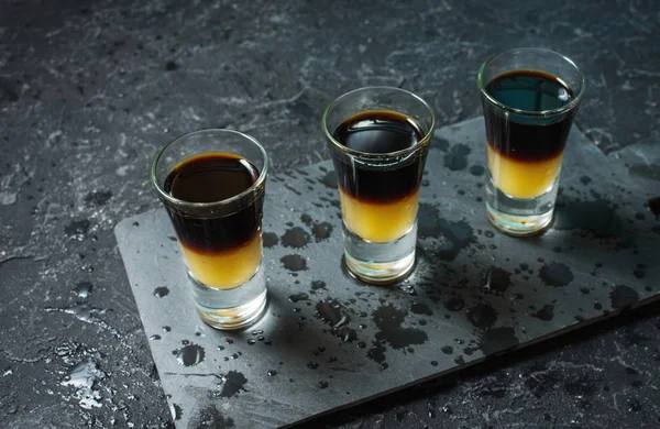 Black Shooter - Black Balsam e suco de pêssego. Difícil tiros alcoólicos na mesa de pedra — Fotografia de Stock