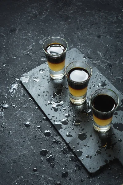 Black Shooter - Black Balsam e suco de pêssego. Difícil tiros alcoólicos na mesa de pedra — Fotografia de Stock