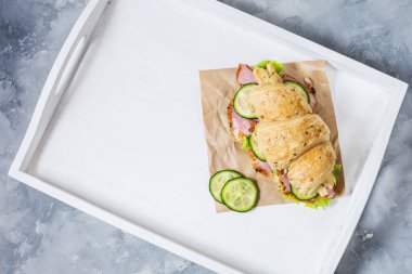 Kruvasan ile peynir, jambon, salatalık ve salata beyaz tepsi