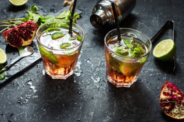 Ferahlatıcı mojito garnet, nane ve içecekler kırbaçlanan Çalkalayıcı ile koyu gri taş tabloda kireç kokteyl