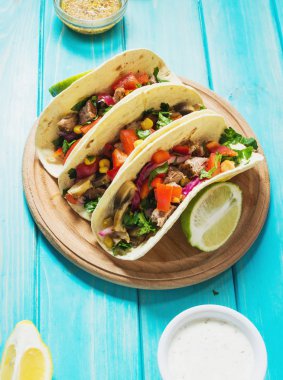 Meksika domuz tacos sebze ile. Tacos al papazı mavi ahşap rustik arka plan üzerinde