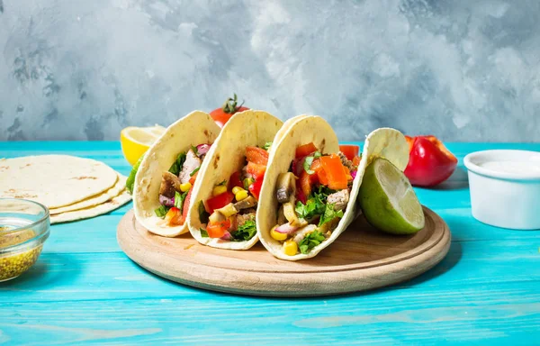Meksika domuz tacos sebze ile. Tacos al papazı mavi ahşap rustik arka plan üzerinde