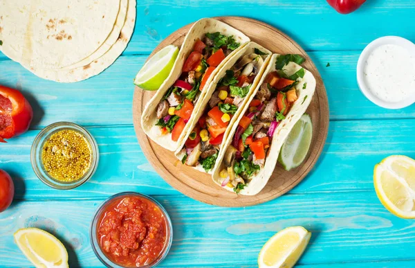 Meksika domuz tacos sebze ile. Tacos al papazı mavi ahşap rustik arka plan üzerinde.