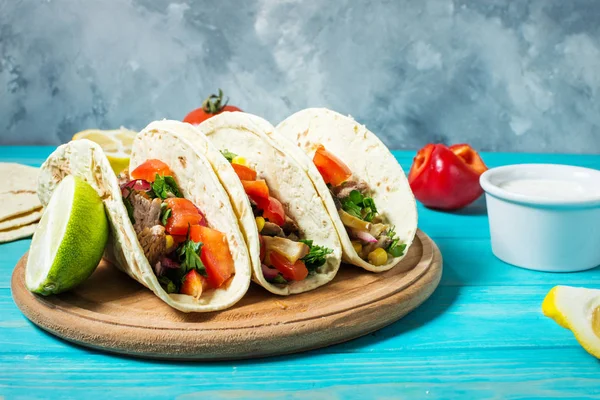 Tacos de cerdo mexicanos con verduras. Tacos al pastor sobre fondo rústico azul madera — Foto de Stock