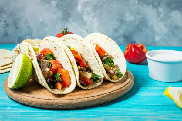 Meksika domuz tacos sebze ile. Tacos al papazı mavi ahşap rustik arka plan üzerinde