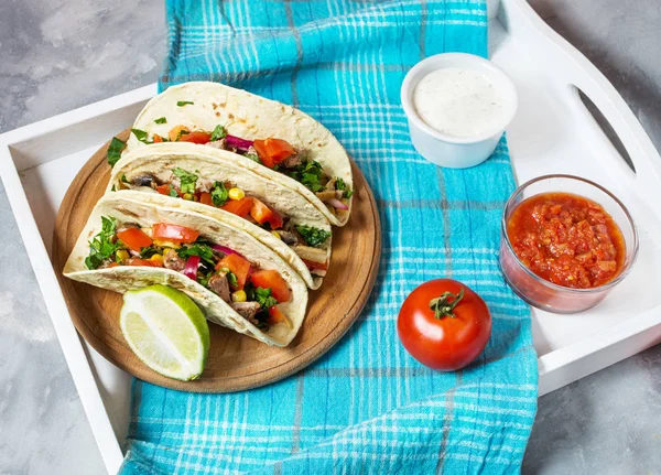 Meksika domuz tacos sebze ile. Tacos al papazı mavi ahşap rustik arka plan üzerinde