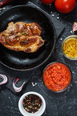 Pan karanlık taş zemin üzerine baharat ile sulu domuz eti biftek