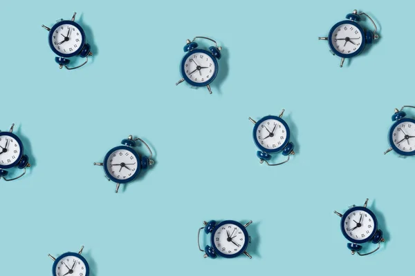 Flat lay retro beautiful new alarm clock on blue color background. Pattern. Top — Stock Photo, Image