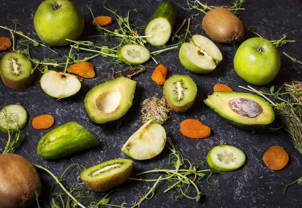 Ingrédients pour le smoothie de cuisine. Légumes et fruits verts bio sur fond de pierre noire — Photo