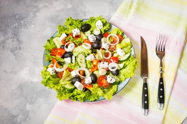 Tradiční Řecký salát s čerstvou zeleninou, sýrem feta a olivami na konkrétní pozadí. — Stock fotografie