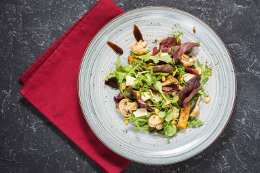 Roka, peynir, mantar ve fındık karanlık taş zemin üzerine taze salata