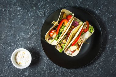 Taş koyu arka plan üzerinde taze lezzetli Meksika tacos