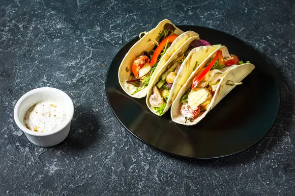 Taş koyu arka plan üzerinde taze lezzetli Meksika tacos