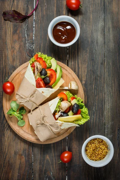 Almuerzo saludable vegano. Tortilla envuelve con setas, verduras frescas sobre fondo de madera . —  Fotos de Stock