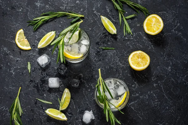 レモン、ローズマリー、石のテーブル上の氷とカクテル酒ジン トニック — ストック写真