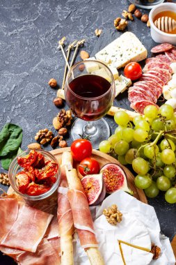 İtalyan antipasto, jambon, peynir, zeytin ve arkaplanda Grissini ekmeği..