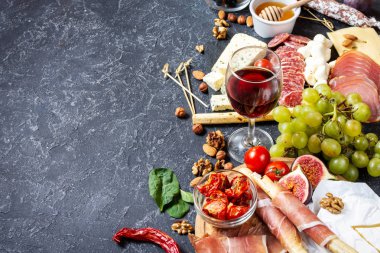 İtalyan antipasto, jambon, peynir, zeytin ve siyah taş arka planda Grissini ekmeği..