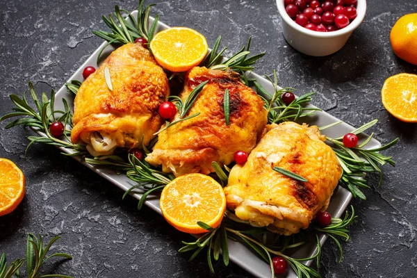 Weihnachtsessen. Hühnerfleisch gebacken mit Preiselbeeren, Mandarinen und Rosmarin auf Steinhintergrund — Stockfoto
