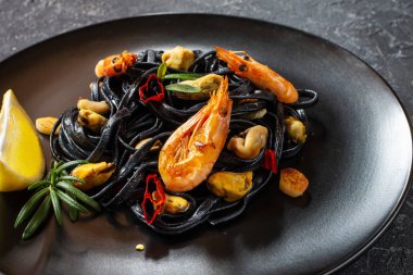 Siyah spagetti. Taş zeminde midye ve karidesli deniz ürünleri makarnası. Akdeniz yemekleri.