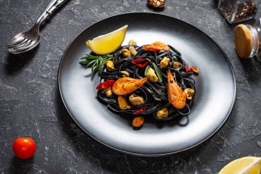 Siyah spagetti. Taş zeminde midye ve karidesli deniz ürünleri makarnası. Akdeniz yemekleri.