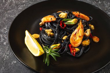 Siyah spagetti. Taş zeminde midye ve karidesli deniz ürünleri makarnası. Akdeniz yemekleri.