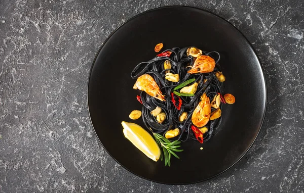 Espaguetis negros. Pasta de mariscos con mejillones y gambas sobre fondo de piedra. Delicias mediterráneas. Vista superior — Foto de Stock