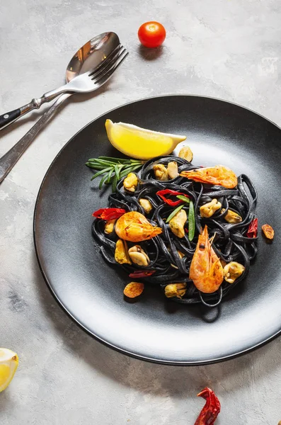 Spaghettis noirs. Pâtes aux fruits de mer avec moules et crevettes sur fond de béton. Nourriture méditerranéenne . — Photo