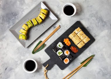 Beton arka planda çeşitli suşi çeşitleri servis edilir.