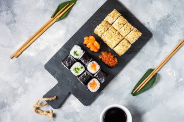 Beton arka planda çeşitli suşi çeşitleri servis edilir.