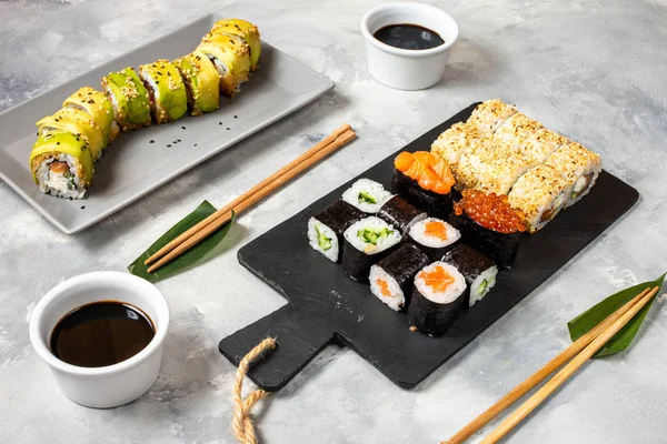 Různé druhy sushi sloužil na betonovém pozadí. — Stock fotografie