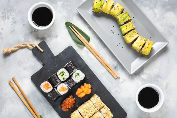 Různé druhy sushi podávané na betonových pozadí. — Stock fotografie