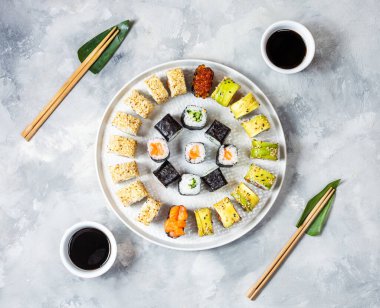 Beton arka planda servis edilen çeşitli suşiler. Üst görünüm