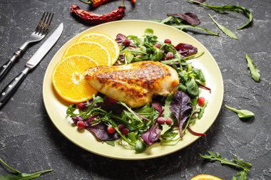 Izgara tavuk göğsü ve koyu taştan arka planda yeşil salata. Sağlıklı yeme kavramı