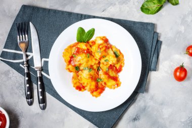 Domates soslu Ravioli ve çimento kaplamalı fesleğen. Lezzetli makarna. Üst görünüm