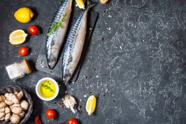 Siyah bir arka planda limonlu ve baharatlı taze çiğ uskumru. Üst görünüm ve kopyalama alanı