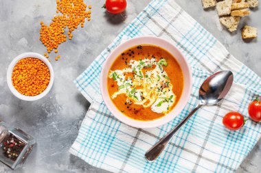 Beton masada kremalı lezzetli mercimek çorbası, kırmızı dolma biber ve ekmek kızartması. Üst görünüm