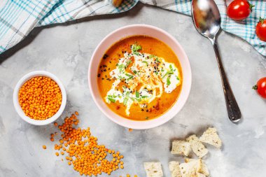 Beton masada kremalı lezzetli mercimek çorbası, kırmızı dolma biber ve ekmek kızartması. Üst görünüm