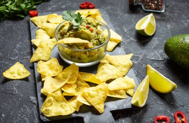 Nachos. Siyah taş zemin üzerinde Guacamole soslu Tortilla cipsi..