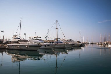 Kıbrıs Rum Kesimi 'nin Limasol Marina limanında mavi gökyüzüne karşı lüks beyaz yatlar