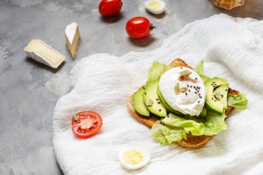 Sağlıklı sandviç - haşlanmış yumurta ve somut arkaplanda domatesli avokado..